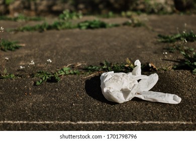 Disposable Medical Gloves Lie On A Sidewalk After Being Worn While Shopping And Then Not Being Disposed Of In The Trash Can