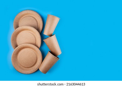 Disposable Paper Biodegradable Cups And Plates On A Blue Background. Top View. Flat Lay Composition.