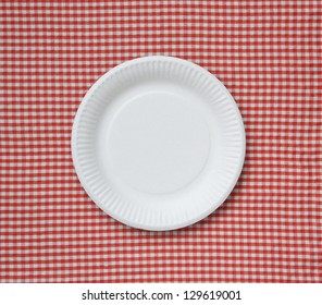 Disposable paper plate on a checkered cloth.