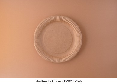 Disposable Paper Plate Top View With Copy Space On Brown Background.