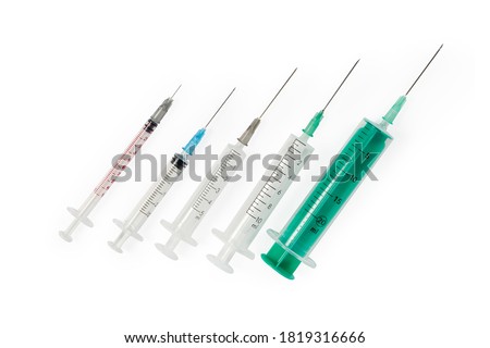 Disposable plastic medical syringes different sizes with hypodermic and intramuscular needles on a white background, top view
