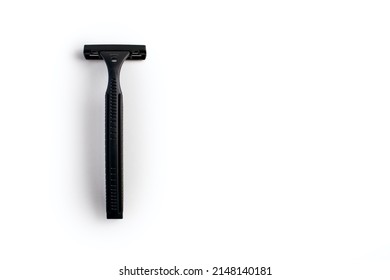 Disposable plastic razor on a white isolated background. Black men's shaving razor with free space for text. Razor for skin care and a neat look for a man