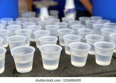 Disposable Plastic Water Cups On Table For Drinking At A Road Race. Plastic Recycling