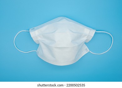 Disposable Protective Masks Of Various Colors On A Blue Background