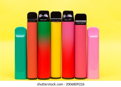 Disposable Single Pink E-cigarettes With Saline Nicotine. Pod Systems In A Row Of Different Colors. Devices For Quitting Smoking. Red, Yellow, Green, Pink And Black.