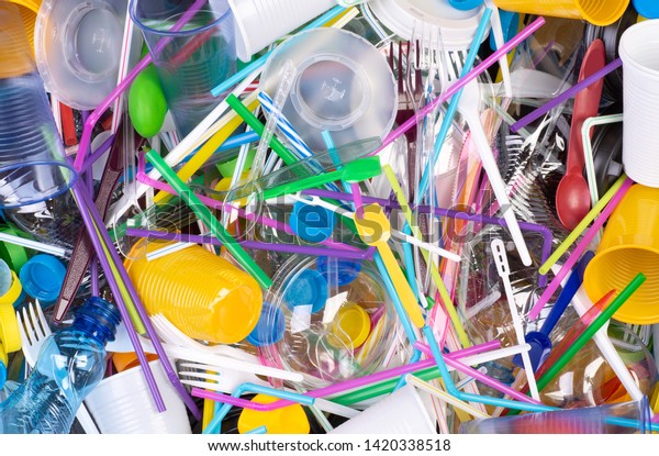 Disposable single use plastic objects\
such as bottles, cups, forks, spoons and drinking straws that cause\
pollution of the environment, especially oceans. Top\
view.