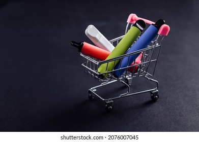 Disposable vapes in a shopping cart on a black background. Modern electronic cigarettes. - Shutterstock ID 2076007045