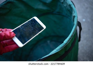 Disposal Of Mobile Phones In The Trash. Throw Away The Smartphone. A Broken Phone With A Cracked Screen Should Be Thrown Into The Trash.