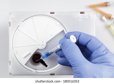 Disposing Medical Waste A Nitrile gloved hand inserting Medical and/or Dental waste into a Sharps container. White background. - Shutterstock ID 180516353