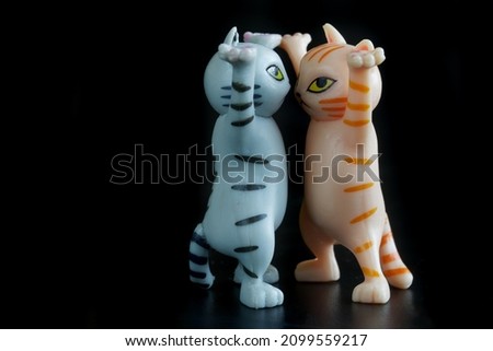 Dispute and conflict of two funny toy kittens on a black background. Rap battle concept and differences of opinion. Free space for an inscription. Close-up