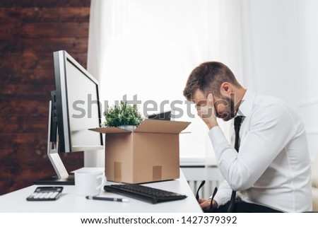 Dissapointed businessman clearing his desk after being made redundant