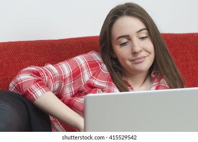  Dissapointed Teenager Girl With Notebook Lying On Sofa