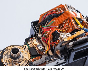 A dissassembled SLR 35mm film camera, top casing removed to show the electronic parts and circuits. Concept for camera repair service, photographic mechanical components and electronics. Copy space.