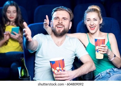 Dissatisfied Couple Watching Film Sitting In The Cinema