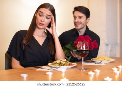 Dissatisfied frustrated beautiful lady ignoring rejecting excited emotional obsessed guy who offering her bunch of red roses. lady turning away. Friendzone And Blind Date Concept, Bad First Impression