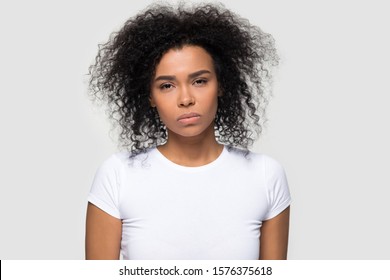 Dissatisfied Millennial African American Woman Looking At Camera, Showing Negative Attitude, Headshot Portrait Irritated Young Female Wearing White T-shirt, Isolated On Studio Background