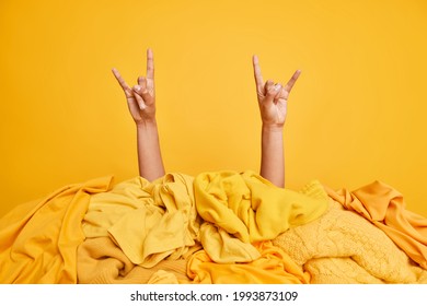 Dissatisfied Sad Woman Feels Tired After Folding Clothes Looks Attentively At Smartphone Checks Newsfeed Leans At Table Surrounded By Two Stacks Of Yellow And Black Folded Laundry Poses Indoor