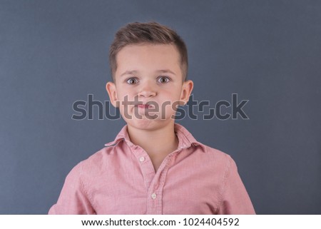 dissatisfied school-age boy in peach shirt