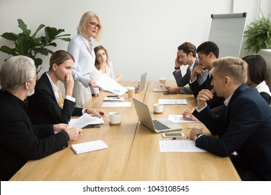 Dissatisfied Senior Woman Boss Scolding Employees For Bad Work At Diverse Group Meeting, Angry Female Executive Team Leader Reprimanding Subordinates For Poor Financial Result At Office Briefing