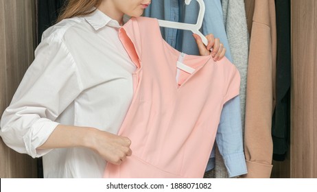 Dissatisfied woman decides what dress to wear, a woman with a pink dress, cropped image, 16:9 - Shutterstock ID 1888071082