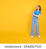 Dissatisfied woman, full body length caucasian 20s dissatisfied woman showing stop sign aside to copy space isolated yellow studio background. Copy space.  Disgust face expression design element.