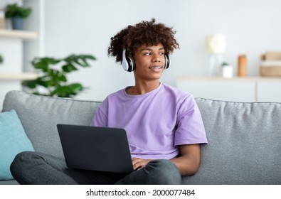 Distance Education. Black Teenager In Headphones Having Online Conference Or Remote Lesson On Laptop Computer At Home. African American Teen Guy Studying Remotely During Covid Lockdown