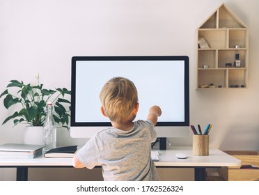 Distance Education Concept. Kids Online Learning. Child Using Computer Technology In Home Schooling. Boy Studying On Internet With Computer With Blank White Screen At Home. Children Homeschooling.