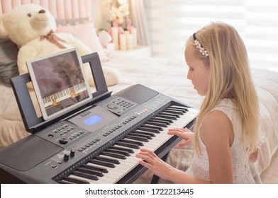 Distance education. Pretty young musician playing classic digital piano at home during online class at home, social distance during quarantine, self-isolation, online education concept - Shutterstock ID 1722213445