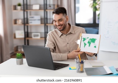 distance education, school and remote job concept - happy smiling male geography teacher with world map and laptop computer having online geography class at home office