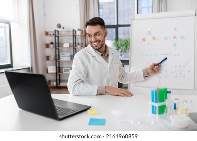 Distance Education, School And Science Concept - Happy Smiling Male Chemistry Teacher With Laptop Computer Having Online Class And Showing Molecular Model On Flip Chart At Home Office