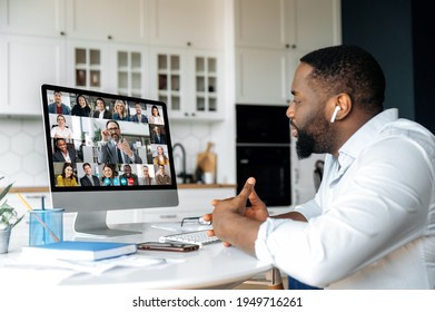 Distance Learning, Online Business Briefing. Successful African American Man Uses Computer For A Video Call, Virtual Meeting With Partners, Sits At Workplace At Home, Multiracial People On The Screen