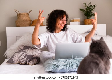 Distance Learning Online Education. European Woman At Home On The Bed. A Man With A Computer Works Remotely. Emotions Of An Adult. Photo In Light Colors. Coronovirus Period. Soft Focus. Copy Space