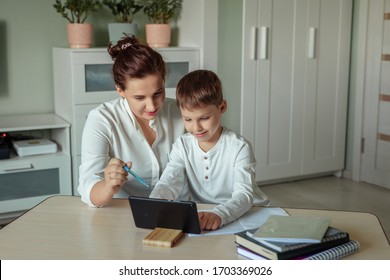 Distance Learning, Online Education At Home During The Covid-19 Pandemic. Family Mom And Son Joyfully Doing Homework In The Room Using Tablet