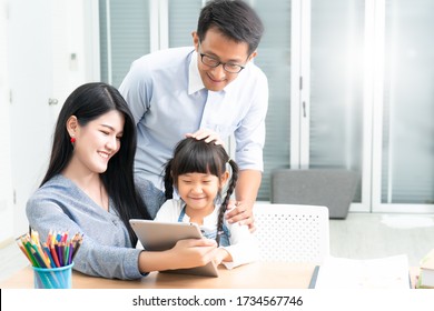 Distance learning online education and Homeschooling concept.Asian girl student video conference e-learning with teacher at home.A parents teaching daughter at home and does school homework.
