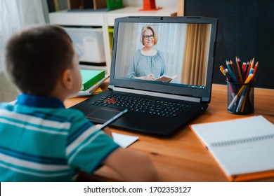 Distance learning online education. A schoolboy boy studies at home and does school homework. A home distance learning.