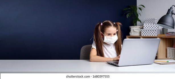 Distance Learning Online Education. Schoolgirl In Medical Mask Studying At Home, Working At Laptop Notebook And Doing School Homework. Covid Quarantine.