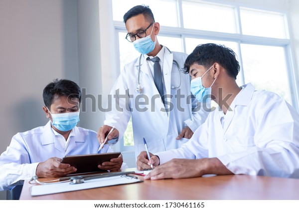 Distance medical\
concept A group of young doctors meeting with a group of doctors\
and nurses are meeting in the Covid 19 epidemic  in Hospital\
Meeting Room or\
Boardroom.