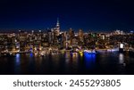 Distancing from a spectacular view of New York, the USA on the waterfront of the East River. Skyline of metropolis at night. Aerial perspective.