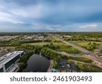 Distant aerial view of downtown Lexington, KY from intersection between New Circle road and Nicholasville road with the pond of Lexington Green shopping and entertainment complex on the foreground.