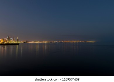 Distant City Lights Watched From Another Side Of The Sea. Night View