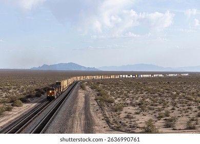 Distant container stack train approaching in desert environment