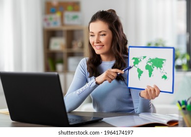distant education, school and people concept - happy smiling female teacher with world map and laptop computer having online geography class at home
