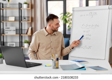 Fernunterricht, Schule und fernes Arbeitskonzept - glücklicher lächelnder männlicher Mathematiklehrer mit Laptop-Berechnung, die Gleichung auf Flip-Chart zeigt, Online-Unterricht oder Videoanruf im Heimatbüro