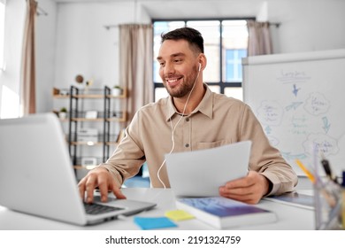 Distant Education, School And Remote Job Concept - Male Teacher With Laptop Computer, Earphones And Papers Working At Home Office