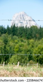 Distant mountain behind barb wired fence