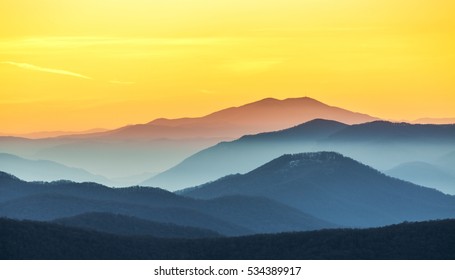 Distant mountain range and thin layer of clouds on the valleys