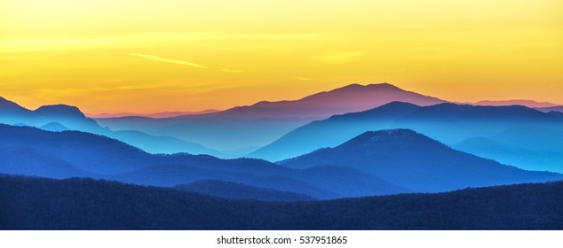 Distant mountain range and thin layer of clouds on the valleys