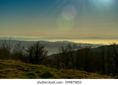 Distant mountain range and thin layer of clouds on the valleys - Misty mountains in the morning. Morning in mountains with Sun rising rural scenery