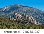 Distant mountains form a backdrop behind rock formations at Castle Rocks State Park, Idaho, USA