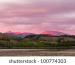Distant mountains glowing in sunset light at Lake Laberge, Yukon Territory, Canada.